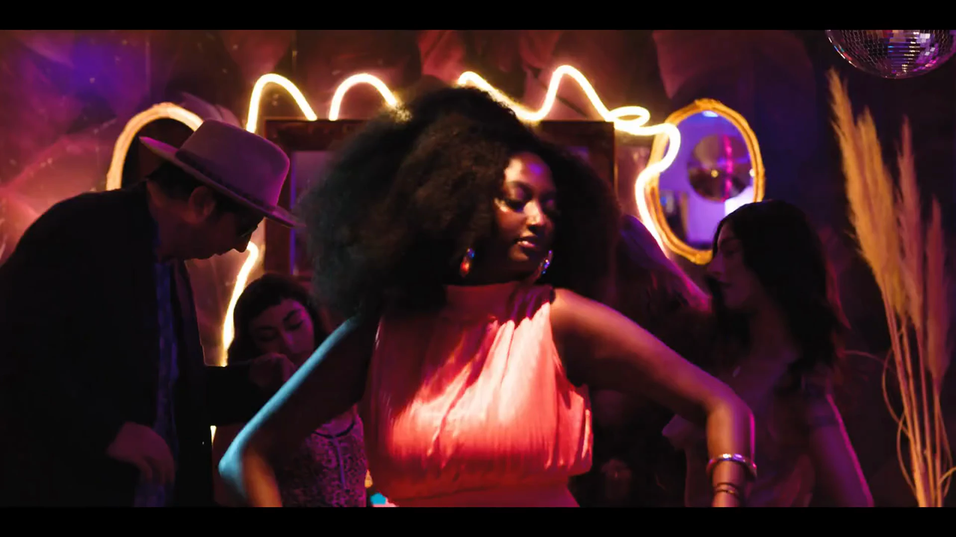 A guest dancing beneath the neon lights at ZEMA